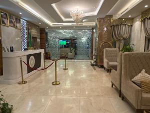 a lobby with a waiting area with chairs and a chandelier at شقق سوار الذهب للشقق المخدومة in Sīdī Ḩamzah