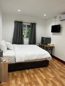 a bedroom with a white bed and a window at AJ Pizza and Steakhouse in Ban Khai Nun