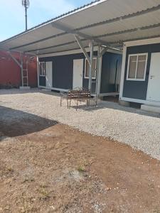 a bench sitting under a building with a roof at Cabinas Nena in Esparza +5 photos