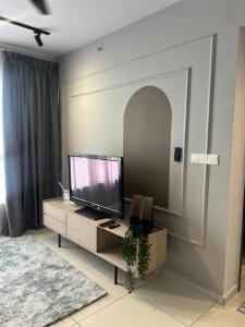 a living room with a flat screen tv on a cabinet at Gamuda Sky Luge Maryam Homestay in Rawang