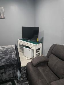 a living room with a couch and a flat screen tv at Newly built Studio Close to NYC and EWR in Irvington +2 photos