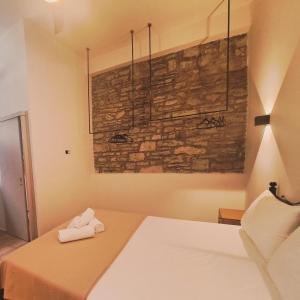 a bedroom with a bed and a brick wall at Mythos Maisonette in Myrina