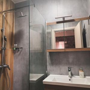 a bathroom with a sink and a glass shower at Mythos Maisonette in Myrina +18 photos