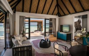 a living room with a view of the ocean at Four Seasons Resort Maldives at Kuda Huraa in North Male Atoll