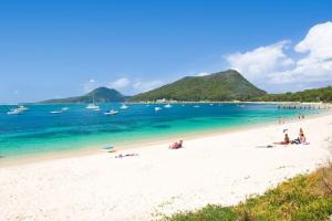 a group of people on a beach with the ocean at Family Beach House with Swim Spa in Nelson Bay