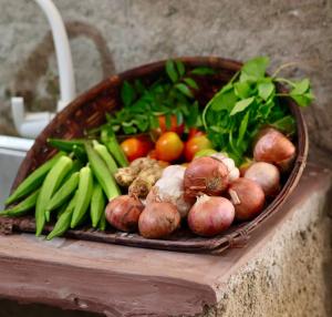 a basket filled with lots of vegetables on a table at Corner Cottage Anuradhapura - Homestay and Cooking Class in Anuradhapura