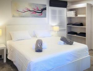 a bedroom with a white bed with shoes on it at Karon beach Stylish large 2BR with Sea View in Ban Karon +13 photos