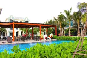 a pool at a resort with a table and chairs at Anh Thư Villa Hồ Tràm in Xuyên Mộc