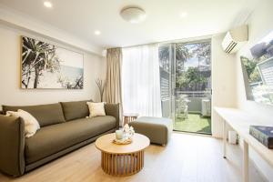 a living room with a couch and a table at Sun, Sand and Stay-Heart of Manly with free parking in Sydney