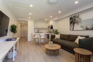 a living room with a couch and a kitchen at Sun, Sand and Stay-Heart of Manly with free parking in Sydney