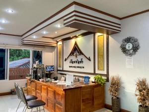 a coffee shop with a counter and a clock on the wall at Rueanchorfa in Nong Bua Lamphu