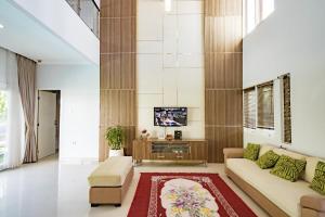 a living room with a couch and a tv at Casa Raya 4BR Villa in Kuta in Kuta
