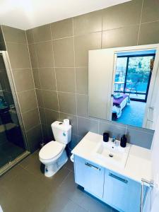 un bagno con un water, un lavandino e uno specchio di Calm Getaway Close to Airport a Melbourne Altre 16 foto