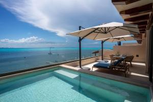 イスラ・ムヘーレスにあるModern Apt with Private Roof Garden & Poolのテーブルとパラソルのあるプール