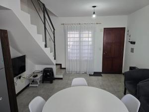 a living room with a staircase and a television at El Punto Las Varillas in Las Varillas