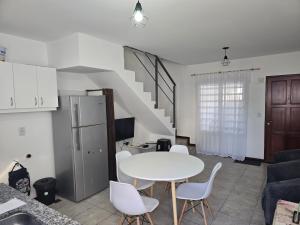 a kitchen and living room with a white table and chairs at El Punto Las Varillas in Las Varillas