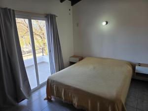 a bedroom with a bed and a large window at El Punto Las Varillas in Las Varillas