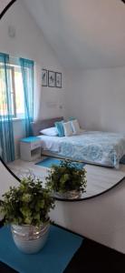 a bedroom with a bed and two potted plants at Hortenzia Apartments in Hvar