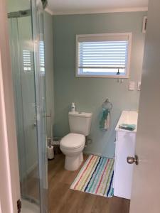 une salle de bain avec toilettes, lavabo et douche dans l'établissement Maraetai Beachfront bliss one bedroom apartment, à Maraetai