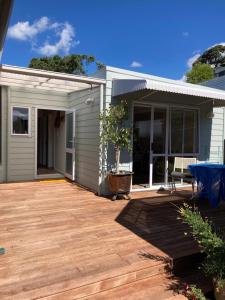 une maison avec une terrasse en bois et un patio dans l'établissement Maraetai Beachfront bliss one bedroom apartment, à Maraetai 8 autres photos