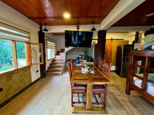 a dining room with a wooden table and a television at Tinny House Villa Victoria in Tinjacá