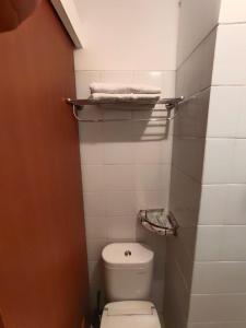 a small bathroom with a white toilet and towels at Golden Knight Suites at EcoHome Apartment in Nalagati