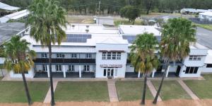 an aerial view of a white building with palm trees at Hotel Theodore in Theodore