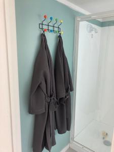 a bathroom with a towel rack and a mirror at Maraetai Beachfront Studio Unit in Maraetai