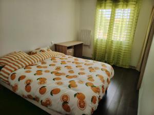 ein Schlafzimmer mit einem Bett mit einer orangefarbenen Bettdecke in der Unterkunft Maison petit havre de paix in Aytré