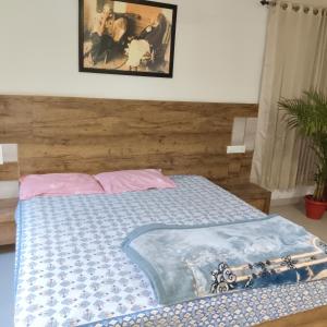 - un lit avec une couette bleue et une peinture murale dans l'établissement Silk Road Suite, à Jaipur