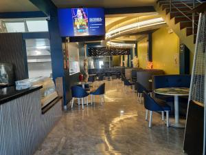 a restaurant with chairs and tables and a tv at Entre Amigos in San Antonio