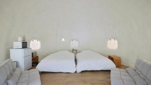 a room with two beds and a couch and lights at ReSchool Nasu Glamp in Nasu