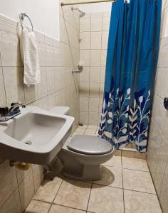 Un baño con inodoro, lavabo y ducha. en Hostal casa el calvarito, en León