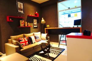 a living room with a couch and a window at The Arni Sukhumvit 101 in Bangkok