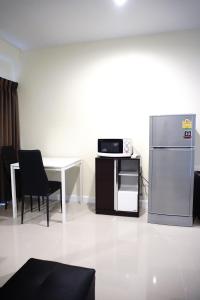 a living room with a refrigerator and a table at The Arni Sukhumvit 101 in Bangkok