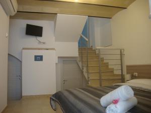マテーラにあるB&B La Gemma dei Sassiのベッドルーム1室(ベッド1台付)、階段(テレビ付)