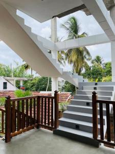a staircase leading up to a house with palm trees at Leema hiriketiya in Nilwella