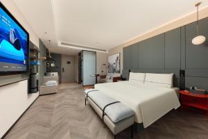 a bedroom with a large white bed and a tv at Atour S Hotel Xiamen Gaoqi Airport Huli District Government in Xiamen +22 photos
