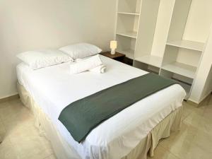 a bedroom with a large white bed with white shelves at Casa Cómoda en Privada con Canchas y Alberca in Cancún