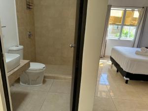 a bathroom with a bed and a toilet and a sink at Casa Cómoda en Privada con Canchas y Alberca in Cancún +13 photos