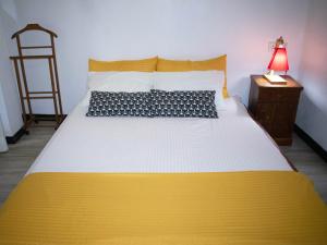 a yellow and white bed in a room with a lamp at Piccolo Villa in Hikkaduwa