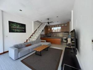 Una sala de estar con un sofá y una cocina. en Villa central seminyak, en Seminyak