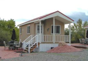 a small house with a porch and a patio at Verde Valley Studio Park Model Cabin 15 in Cottonwood