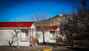 a white house with a red roof and a mountain at Verde Valley One-Bedroom Park Model Cabin 14 in Cottonwood