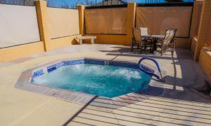 a swimming pool on a patio with a table and chairs at Verde Valley One-Bedroom Park Model Cabin 14 in Cottonwood +12 photos