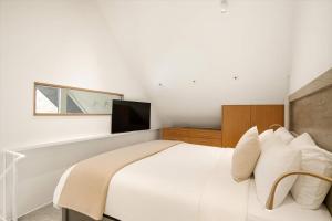 sypialnia z białym łóżkiem i telewizorem w obiekcie Top Floor Modern Ski-in & Out 3 BR Views w Aspen +30 zdjęć