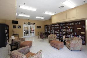 uma biblioteca com sofás e cadeiras e estantes em Sherwood Forest Cottage 6 em Kissimmee
