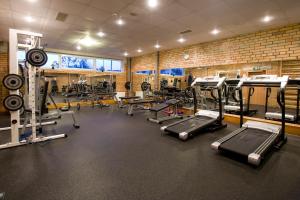 a gym with a lot of treadmills and machines at Tukuma Ledus Halle in Tukums