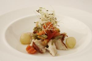 un piatto bianco di alimenti con carne e verdure di B&B Ristorante del Monte a Colleretto Giacosa