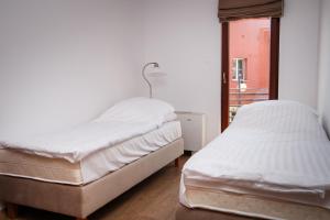 two twin beds in a room with a window at Nowa Apartamenty in Krynica Morska